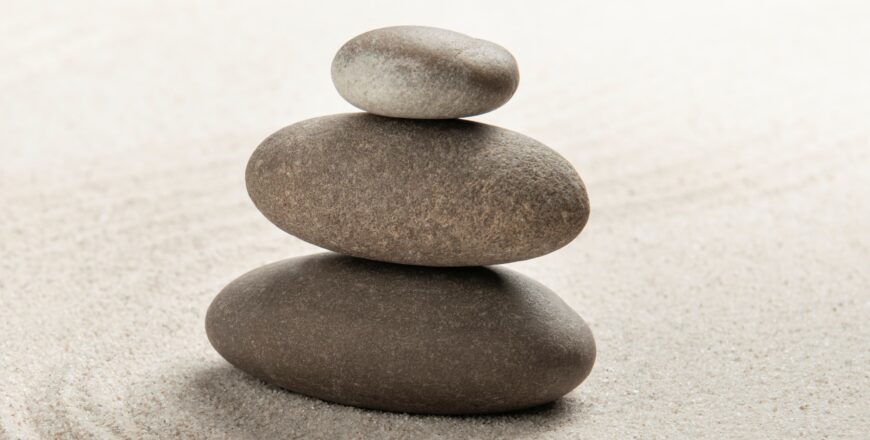 Stacked zen stones sand background art of balance concept